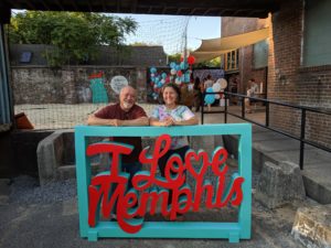 Cat and Jesse at I Love Memphis party Cat (owner of Cat's Ballroom) and Jesse standing behind and I Love Memphis sign.