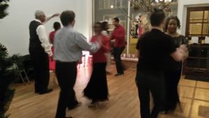Group of people dancing at a party and exhibiting ballroom etiquette.