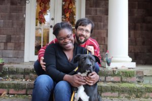 couple sitting on steps with dog