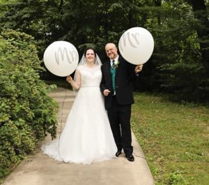 bride and groom with mr and mrs balloons