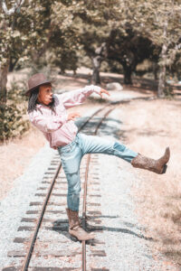 man on railroad track doing awkward dance move