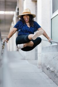 Happy woman swinging on rails representing why you really dance.