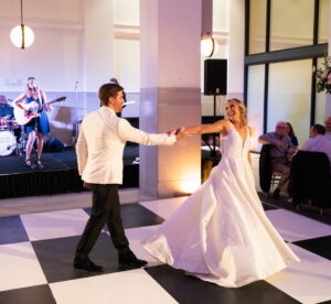 Bride and groom dancing with band in background