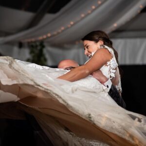 Happy bride and groom executing a lift during their first dance.