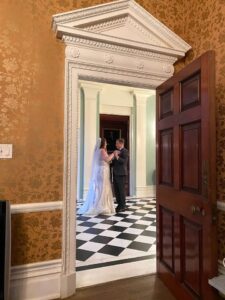 Sara and Ben practicing their first dance in a hallway.