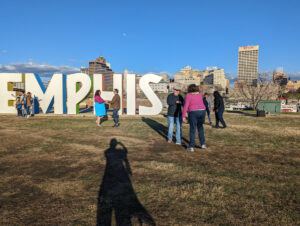 Students from Cat's Ballroom warming up for Cat Tracks No. 3 in front of the Memphis Sign while tourists take selfies.