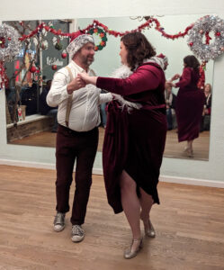 Couple dressed as Mr. and Mrs. Claus doing heel toe swivels at the Cat's Ballroom 2022 Winter Show