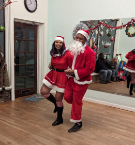 Couple dressed as Mr. and Mrs. Claus doing hops at the Cat's Ballroom 2022 Winter Show