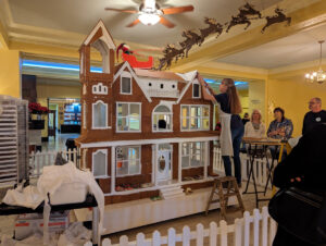 Workers adding pieces to a large gingerbread house at the Arlington.